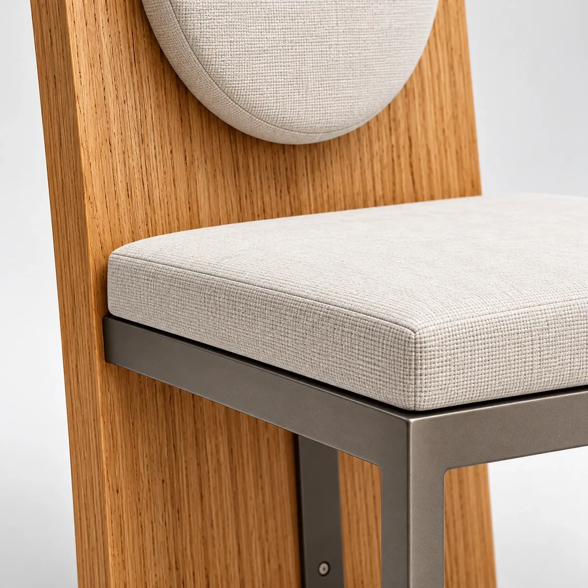 Close product view showing the chair's natural oak grain, ivory upholstery and graphite frame connection.